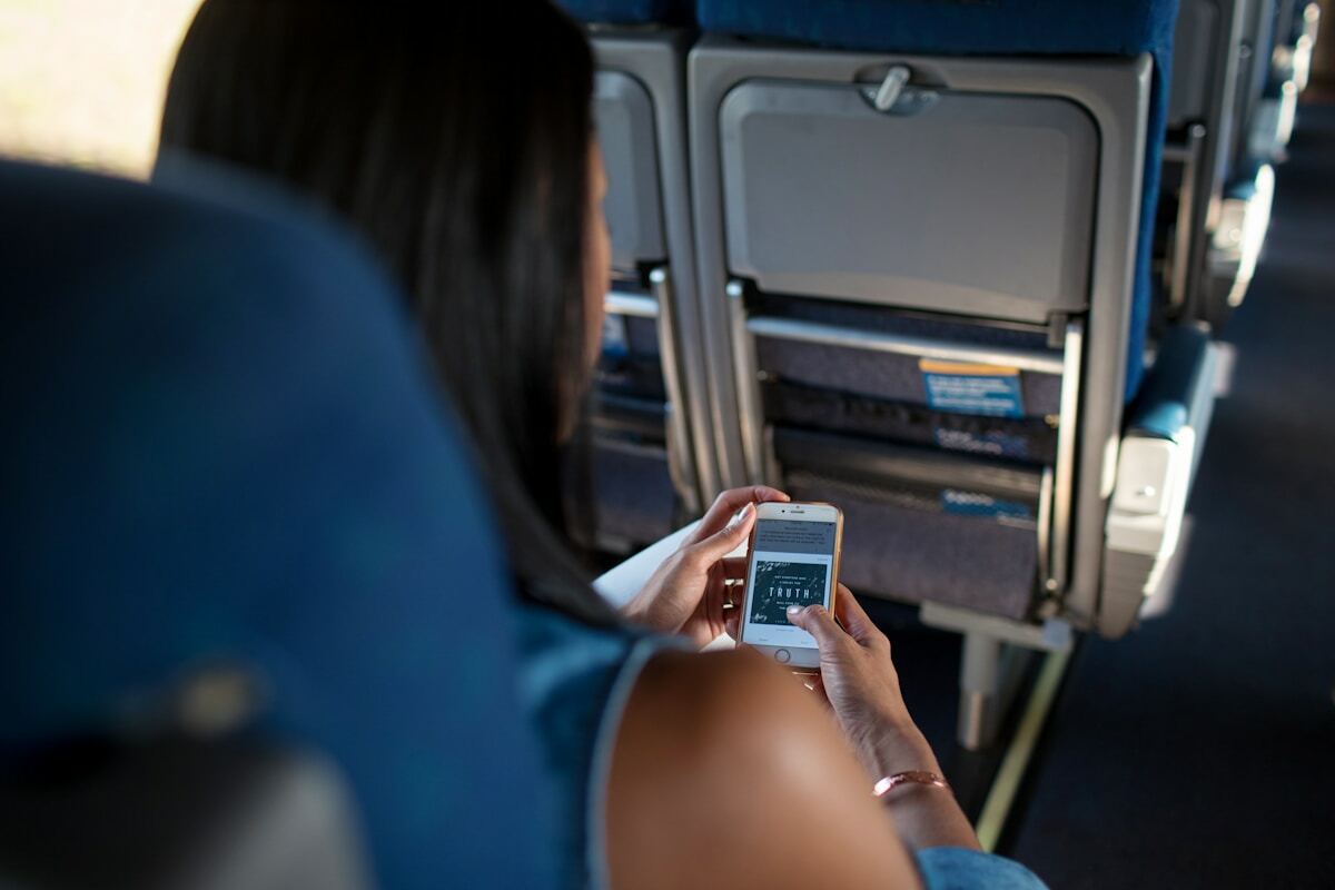 Personne utilisant un smartphone dans un véhicule de transport en commun.