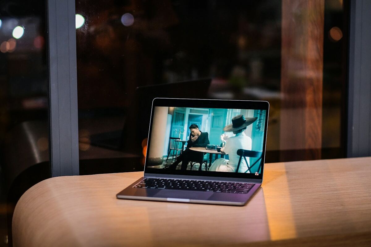 Ordinateur portable affichant une scène de film dans un café sombre.