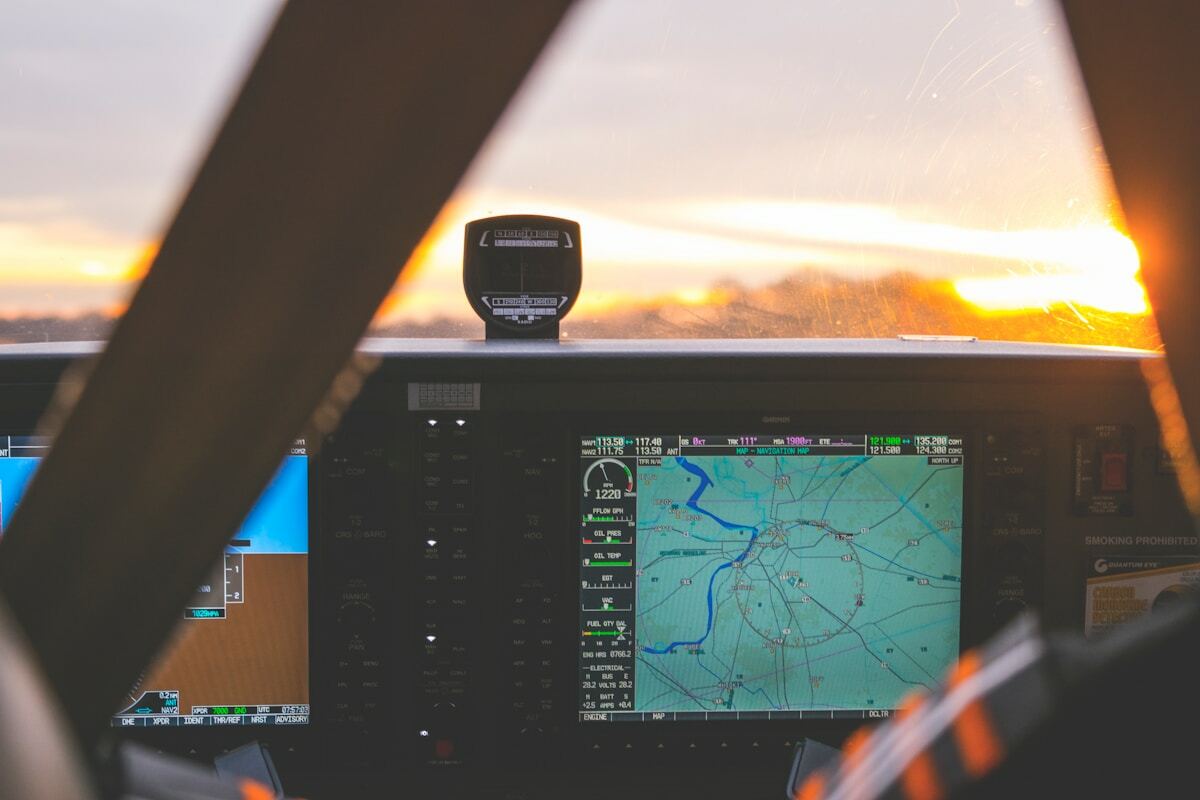 Tableau de bord d'un avion avec écran de navigation et instruments de vol.