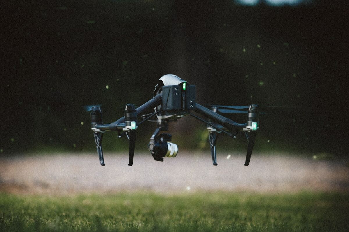 Drone volant au-dessus d'un champ par une nuit étoilée.